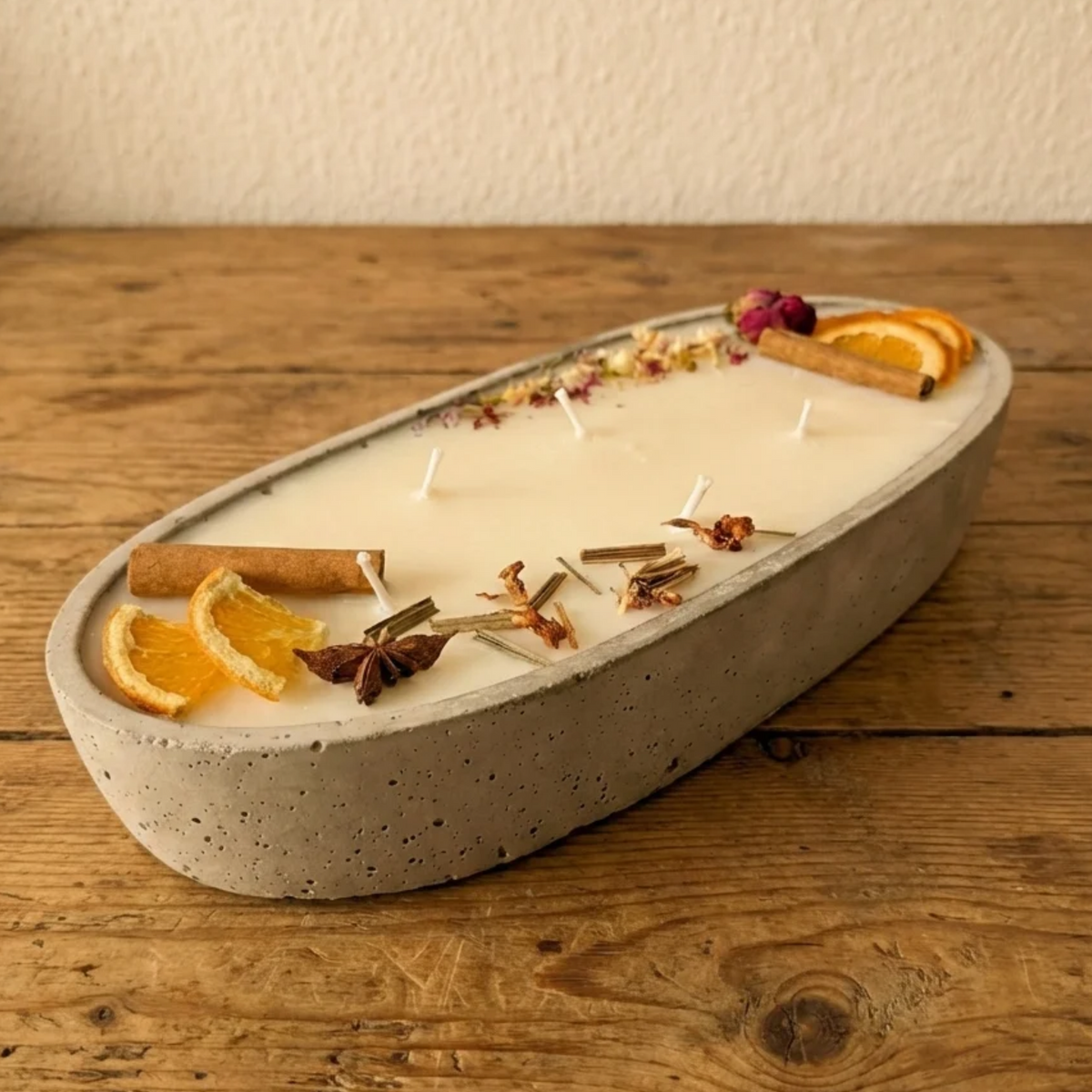 Handgegossene Betonschale Kerze in Grau mit Winterdeko aus Orangen, Sternanis und Rosenknospen