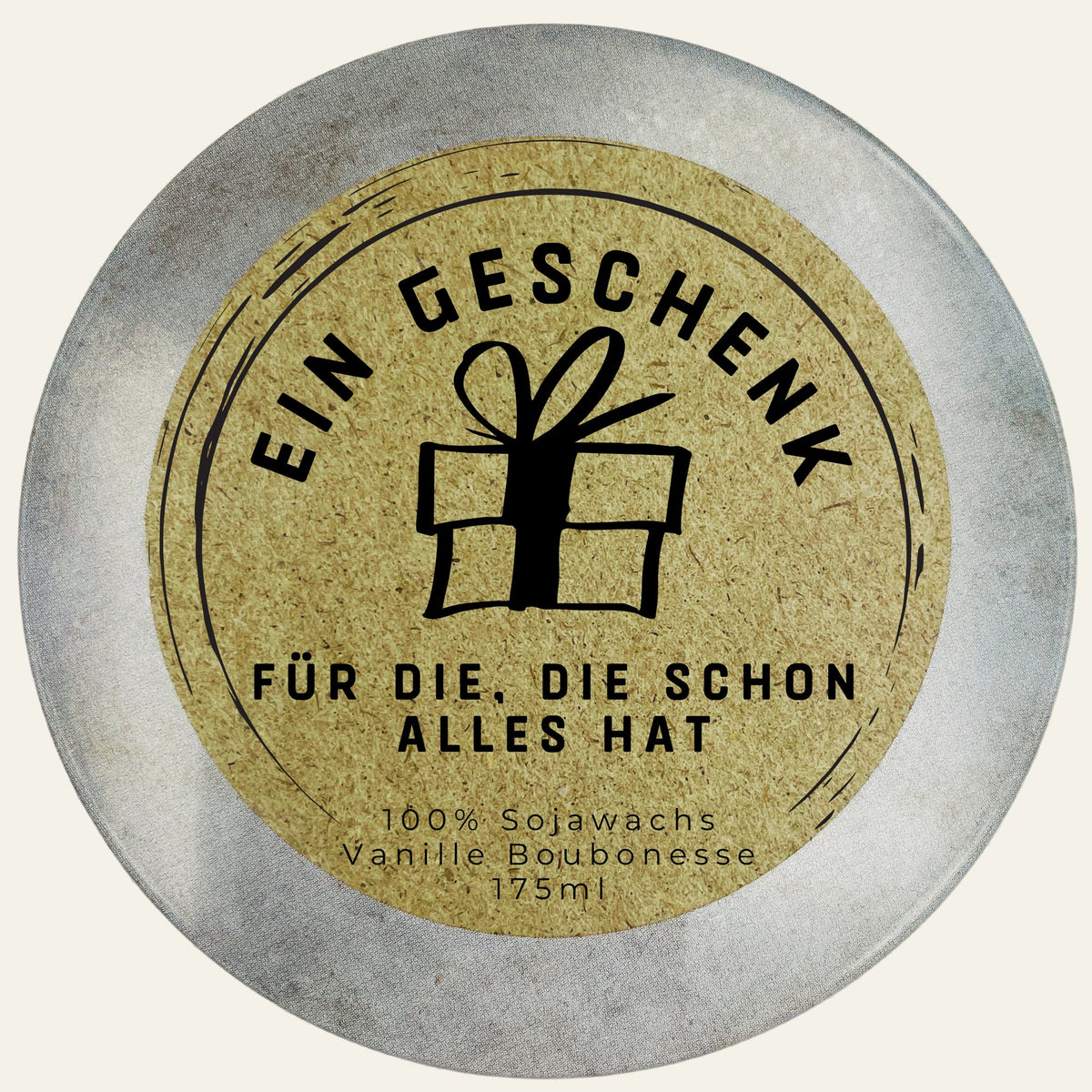 Dosendeckel mit Kraftpapier-Etikett, Geschenk-Symbol und Spruch „Ein Geschenk für die, die schon alles hat“